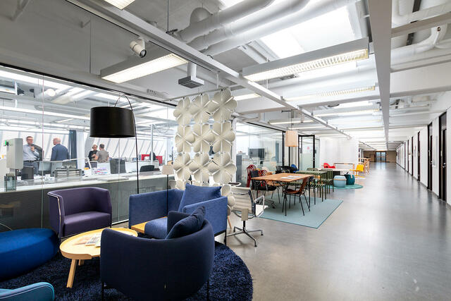 Helsingin Melkonkatu 26 toimistohotellialueen käytävä. Toimistotiloihin on lasiseinät, jaetulla alueella oleskelutilaa.