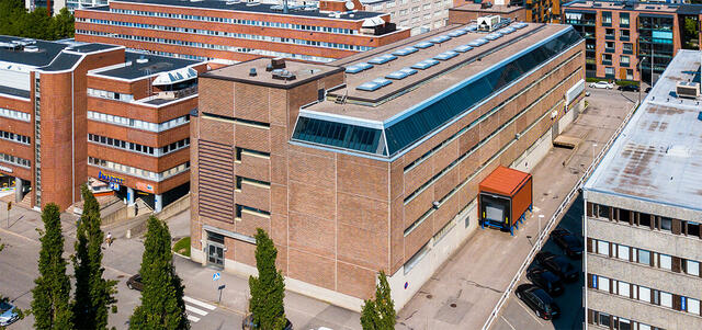 Helsingin Melkonkatu 26 ilmakuvattuna Itälahdenkadulta. Punatiilisen toimitilarakennuksen seinustalla on nauhaikkunat.